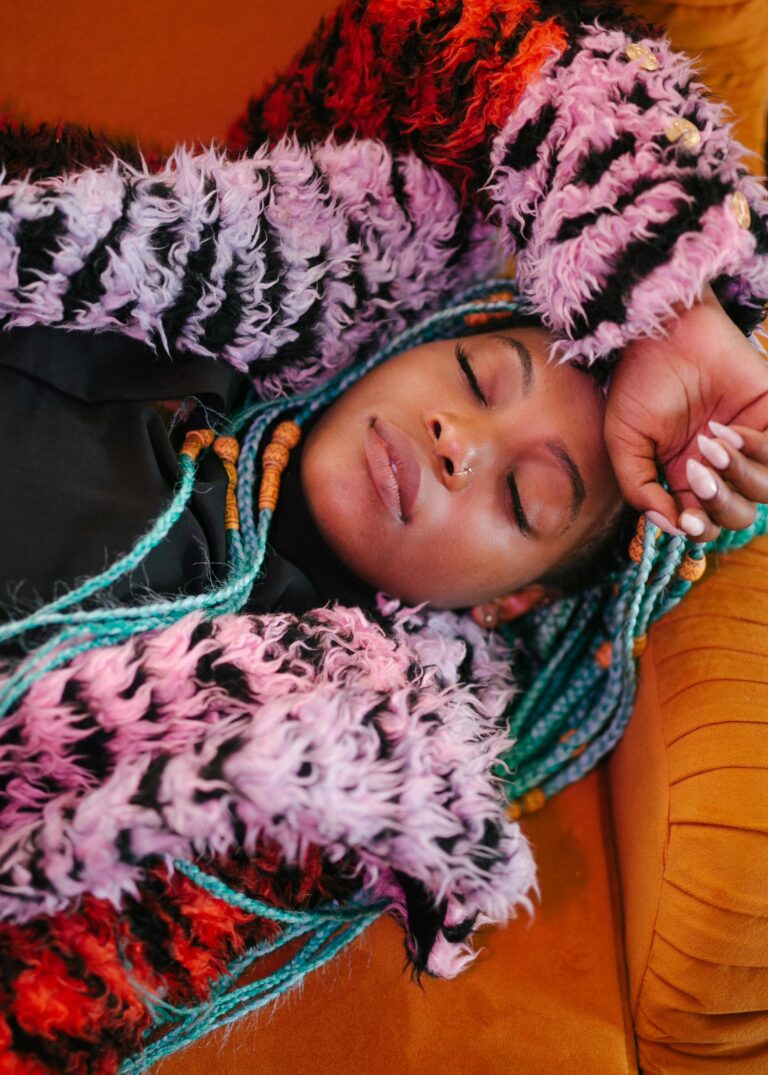 Serene portrait of a woman resting comfortably in colorful, textured clothing.