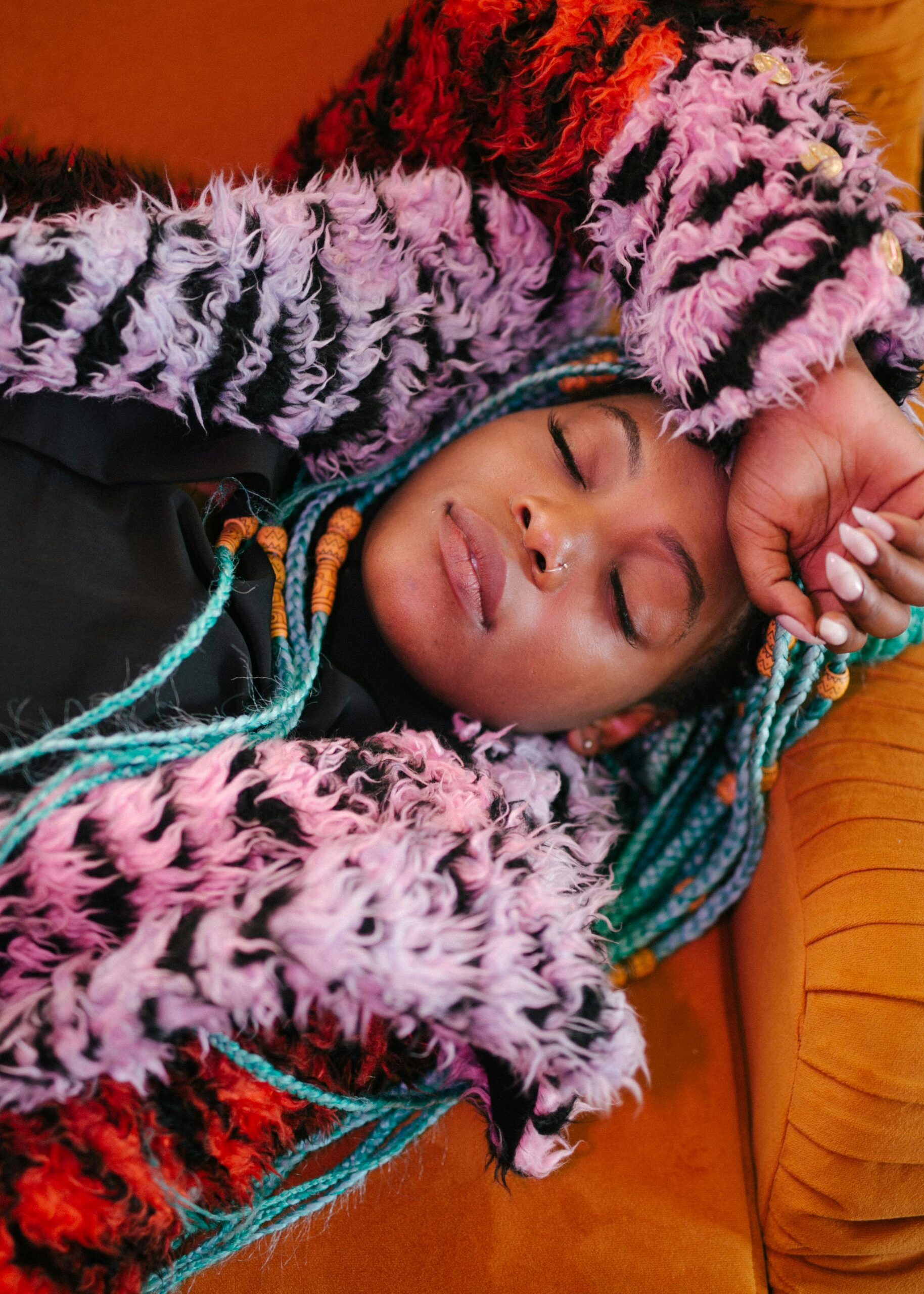 Serene portrait of a woman resting comfortably in colorful, textured clothing.
